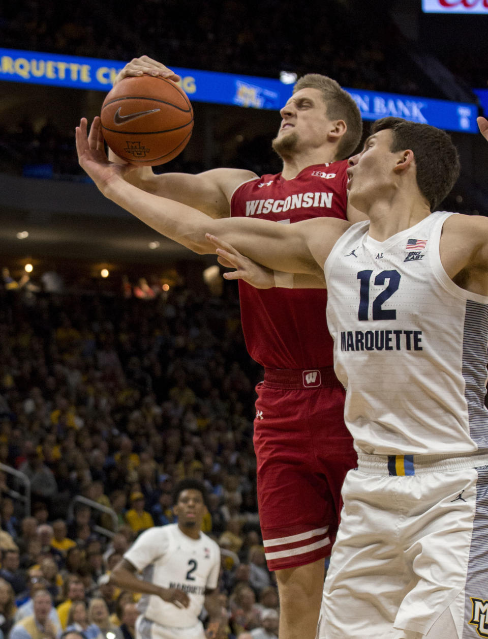 Wisconsin guard Brevin Pritzl, left, and Marquette center Matt Heldt, right, battle for the rebound during the first half of an NCAA college basketball game Saturday, Dec. 8, 2018, in Milwaukee. (AP Photo/Darren Hauck)