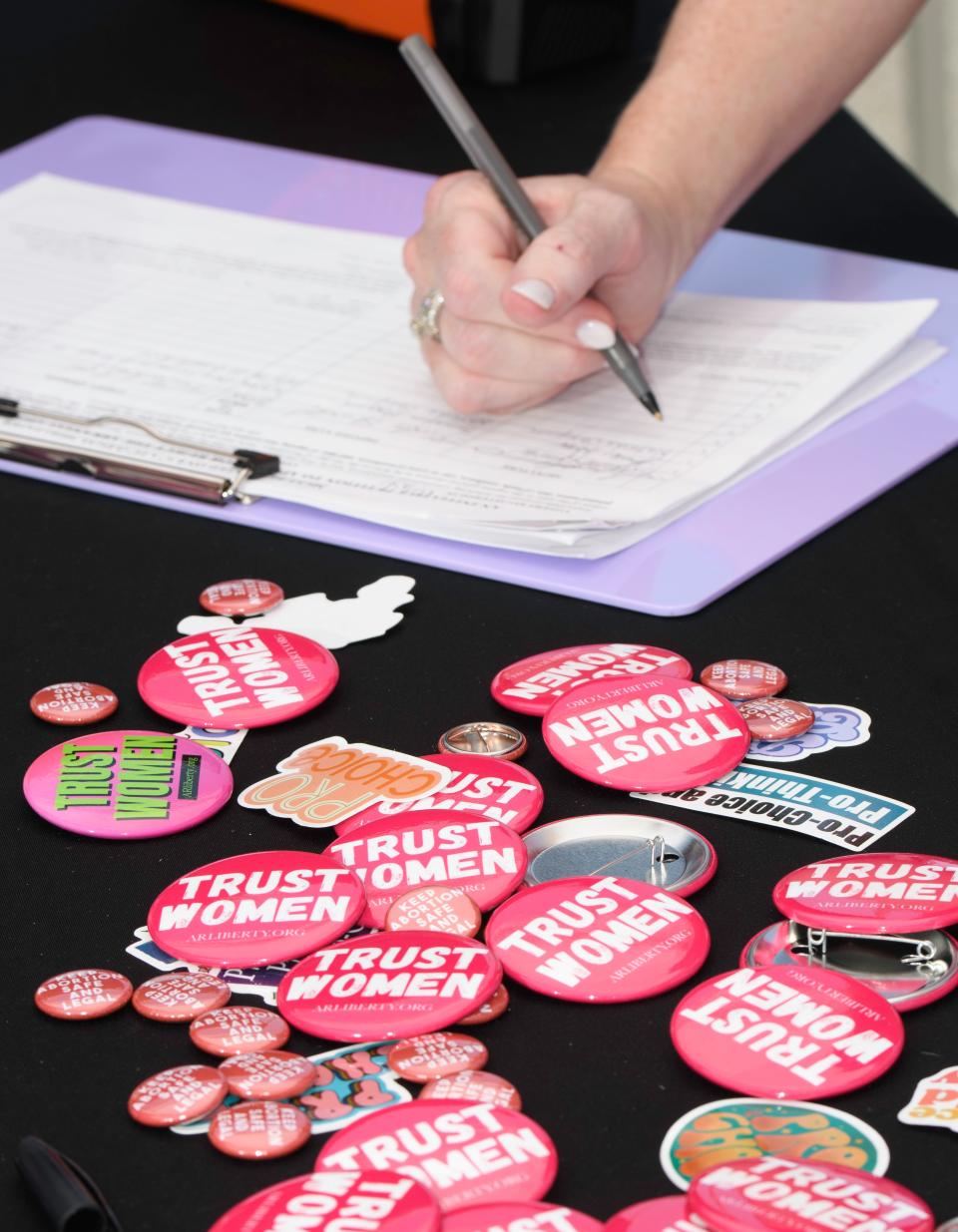 A visitor signs the petition for the Arkansas abortion amendment during the 15th Annual Juneteenth in Da Rock celebration at S. Arch Street in Little Rock, Ark., Saturday, June 15, 2024.