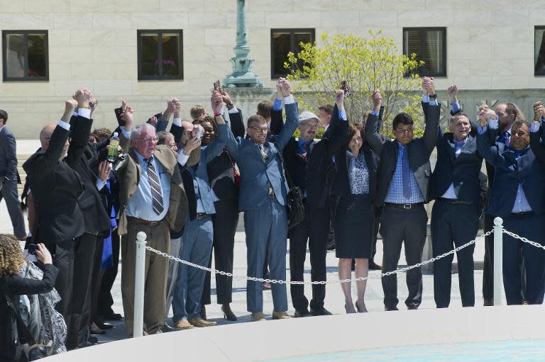 Plaintiffs and legal teams for marriage equality raise arms outside US Supreme Court at the conclusion of hearings for marriage equality on April 28, 2015 in Washington, DC