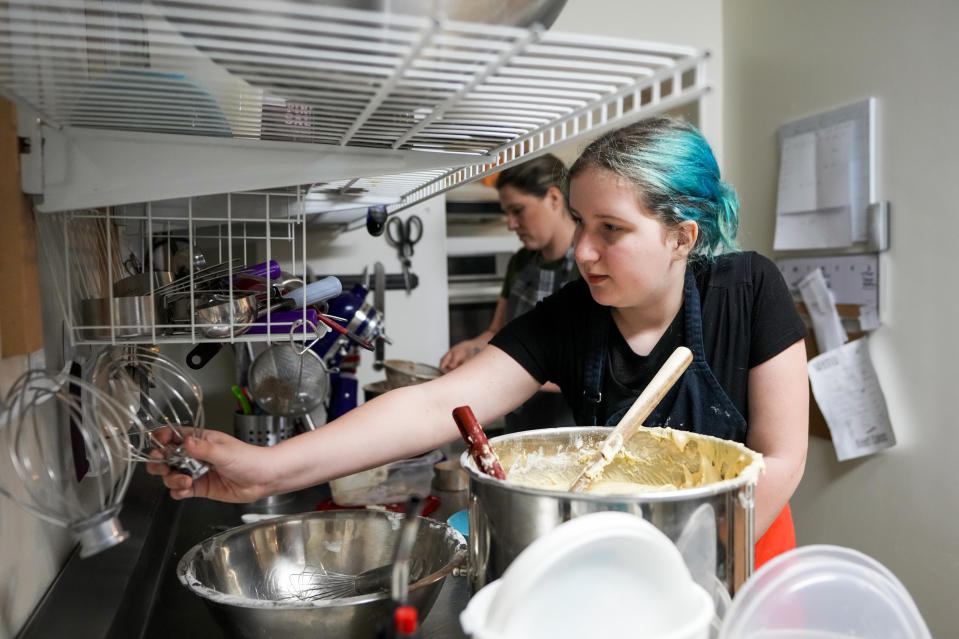 Khloe Warne, 12, makes cupcakes with her mother, Alyssa, at the family bakery Beef Cakes, Thursday, May 18, 2023, in Grants Pass, Ore. Not being able to attend school regularly has saddened Khloe, stunted her education and isolated her from her peers, her mother says. It has also upended her family’s life. Her mother had to quit her job for a time in order to stay home with her. She described the fight to get her daughter back in the classroom as exhausting, stressful and sad. (AP Photo/Lindsey Wasson)