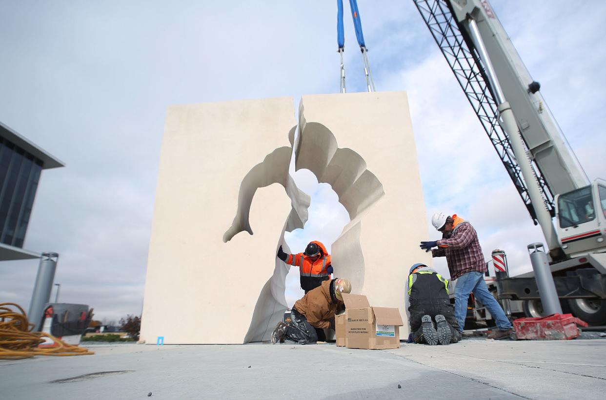 Seedorff Masonry workers install pieces of the 200,000-pound concrete and bronze “Breaking Barriers" sculpture commemorating the 100th anniversary of Jack Trice’s death, in front of Jack Trice Stadium on Tuesday, Oct. 25, 2022, in Ames, Iowa.