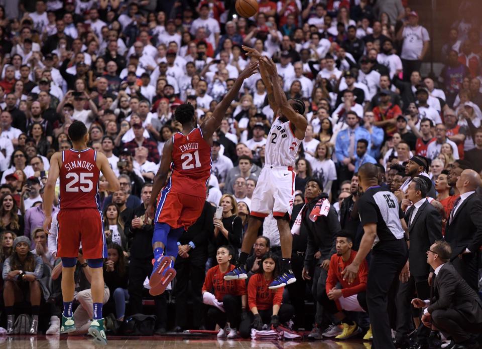 May 12, 2019; Toronto, Ontario, CAN; Toronto Raptors forward Kawhi Leonard (2) shoots the game winning basket over Philadelphia 76ers center Joel Embiid (21) to win game seven of the second round of the 2019 NBA Playoffs at Scotiabank Arena. Mandatory Credit: Dan Hamilton-USA TODAY Sports