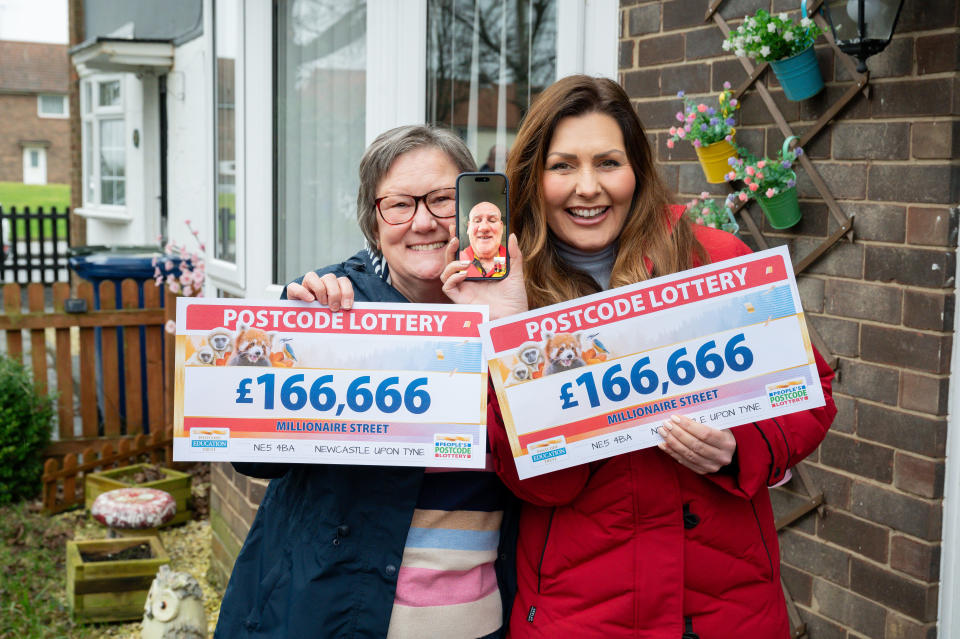 Christine Hedley holding her winning tickets worth £166,666 each