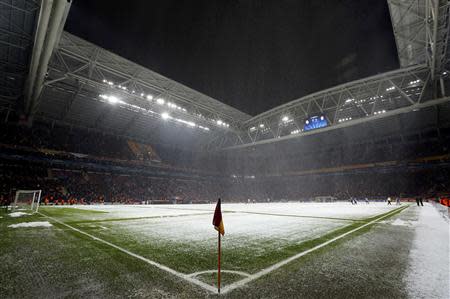 Workers clean the snow from the pitch after the Champions League soccer match between Galatasaray and Juventus was paused for 20 minutes due heavy snowfall in Istanbul December 10, 2013. REUTERS/Murad Sezer