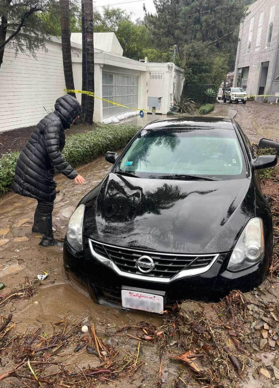 A black Nissan half submerged in mud was abandoned at the scene of the mudlside in Beverly Crest (Mike Bedigan / The Independent)