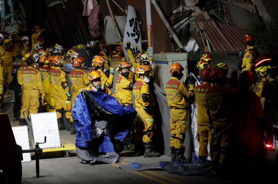 Firefighters prepare to move victims’ bodies outside a collapsed building during a rescue operation following an earthquake in Hualien City, in eastern Taiwan.<span class="copyright">Chiang Ying-ying—AP</span>