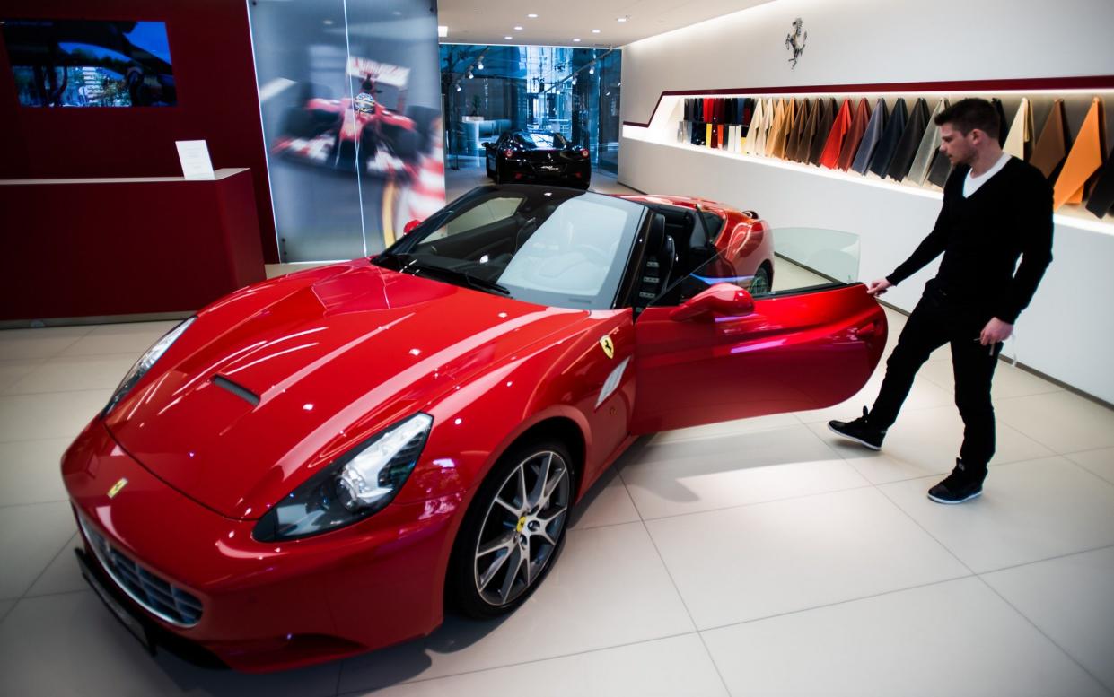 A buyer examines a Ferrari California in the showroom of a Ferrari dealership - Akos Stiller/Bloomberg