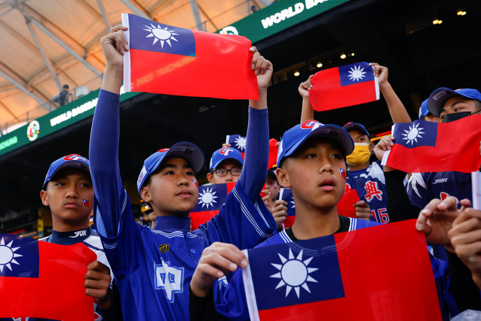 Baseball players hold the Taiwanese flag while waiting for the match between Taiwan and Panama in the 2023 World Baseball Classic game in Taichung, Taiwan March 8, 2023. REUTERS/Ann Wang