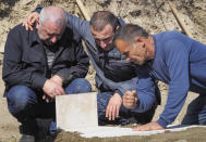 People grieve at the grave of their relative and friend killed during a military conflict, at a cemetery in Stepanakert, the separatist region of Nagorno-Karabakh, Sunday, Oct. 18, 2020. Armenia and Azerbaijan are trading accusations of violating the new cease-fire in their conflict over the separatist Nagorno-Karabakh territory despite a true announced Saturday that was supposed to take effect at midnight. It is a second attempt to establish a cease-fire in the region since heavy fighting there broke out on Sept. 27. (AP Photo)