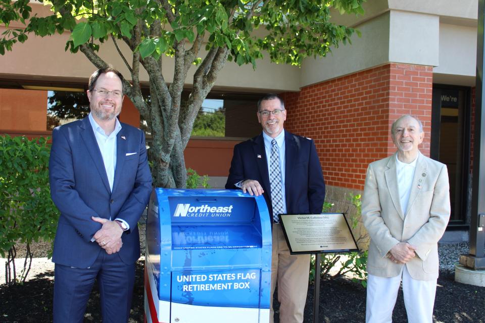 Chris Parker, Northeast CU President/CEO, Ray Bald, Northeast CU Board Chairman and Vic Collinino, Northeast CU Board Member celebrate in front of the newly dedicated flag retirement box
