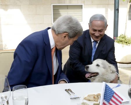 Israeli Prime Minister Benjamin Netanyahu (R) shows U.S. Secretary of State John Kerry his recently adopted dog Kaiya, during their meeting in Jerusalem November 24, 2015. REUTERS/Matty Stern/U.S. Embassy Tel Aviv/Handout