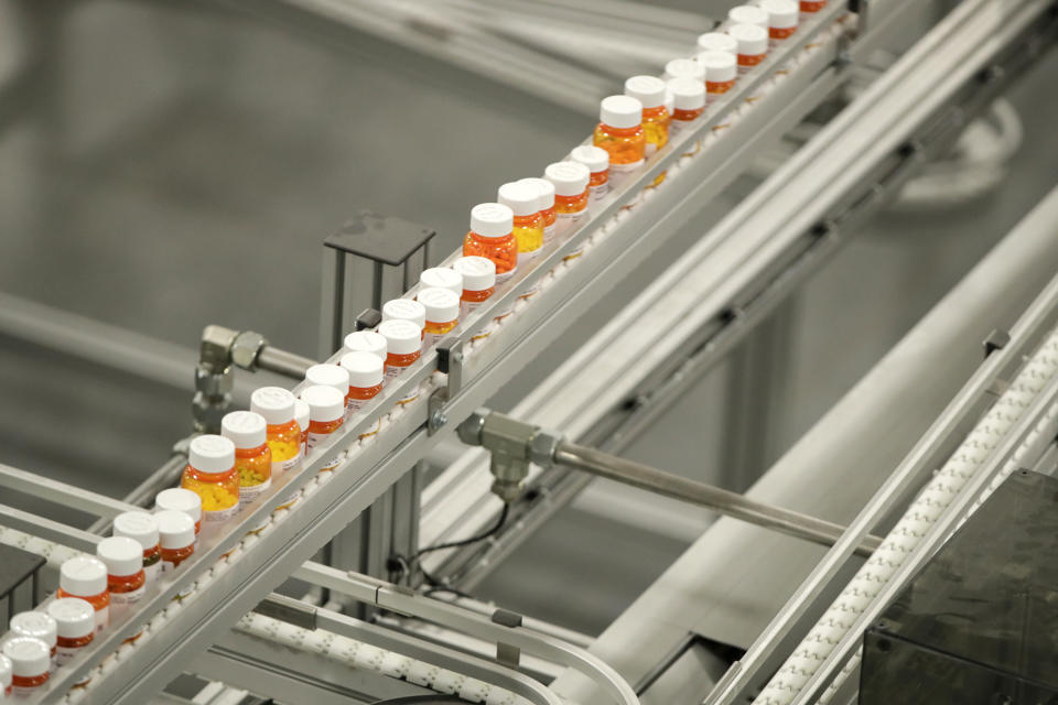 Bottles of medicine ride on a belt at the Express Scripts mail-in pharmacy warehouse, Tuesday, July 10, 2018, in Florence, N.J. (AP Photo/Julio Cortez)