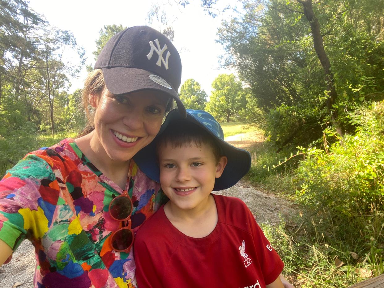 Melissa Noble and her son smiling while walking outside on a trail.