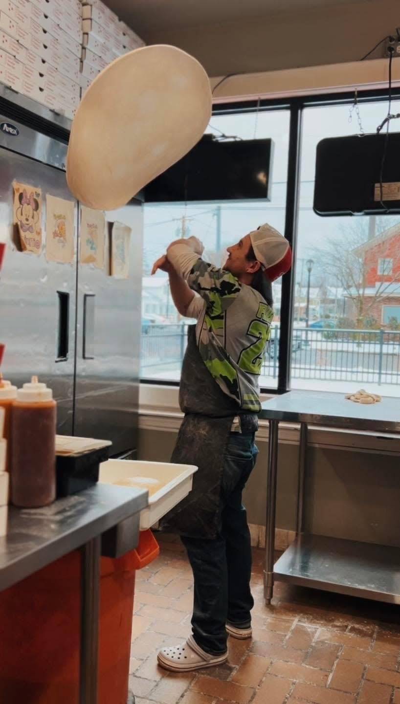 An employee of Big Jay's Pizzeria hand-tosses pizza dough.