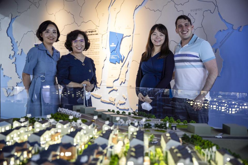 Four people stand around a model of a "smart city"