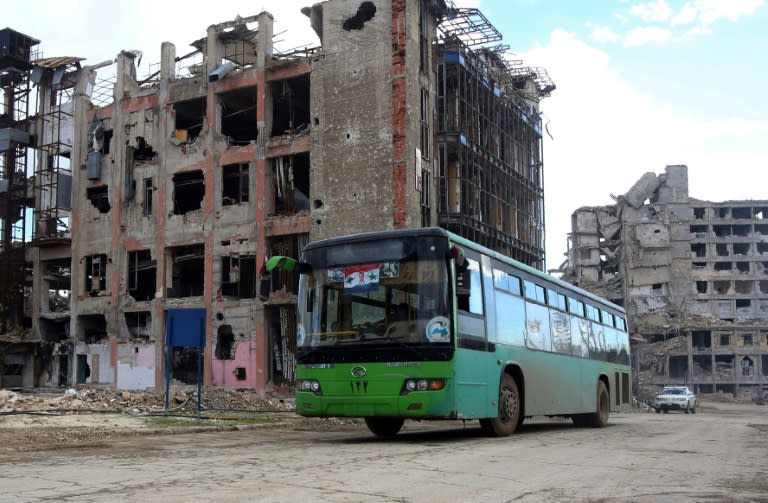 A bus with local people on board drives through Aleppo's government-held Shihan neighbourhood