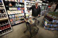 In this March 24, 2020, photo David Leeson, of Winterset, Iowa, shops at the Gateway Market in Des Moines, Iowa. While most governors have imposed stay-at-home orders to slow the spread of the coronavirus, leaders of a handful of states have rejected such action. (AP Photo/Charlie Neibergall)