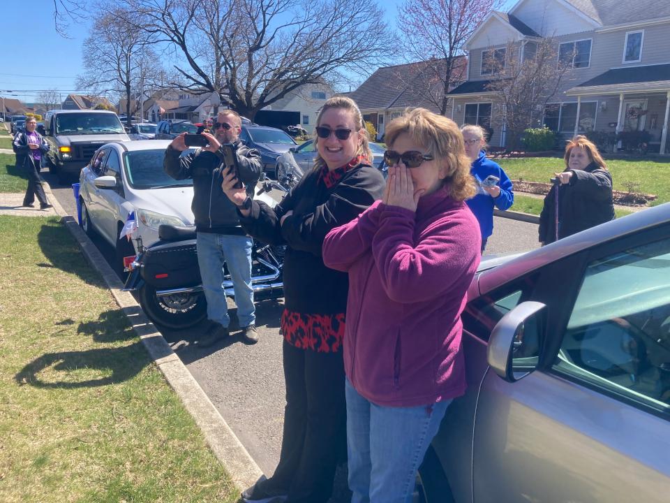 Sandra Small (left) beams while standing next to friend Darlene Csolak (right) as they watch neighbors and friends greet Sandra's son, Matt in Levittown, March 30, 2023.