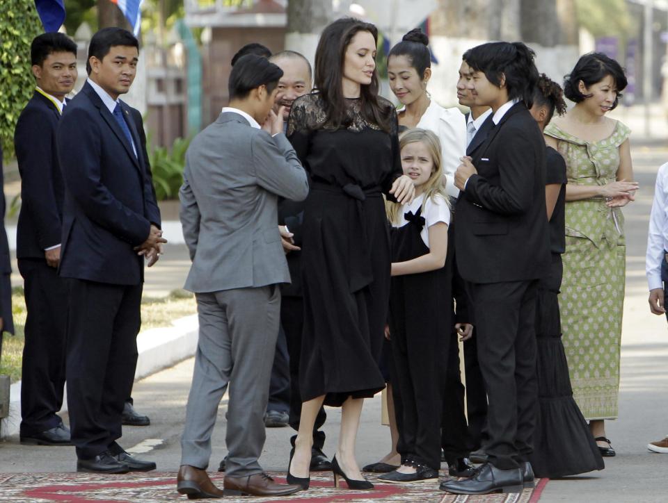 Hollywood actress Angelina Jolie, center, stands with her group members as they wait before meeting Cambodia's King Norodom Sihamoni, in Siem Reap province, north of Phnom Penh, Cambodia, Saturday, Feb. 18, 2017. Jolie on Saturday launch her two-day film screening of "First They Killed My Father" is presiding over by King Sihamoni, in Angkor complex in Siem Reap province. (AP Photo/Heng Sinith)