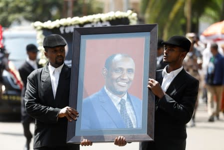 Men carry the photo of Amhara president Mekonnen during a funeral ceremony in the town of Bahir Dar
