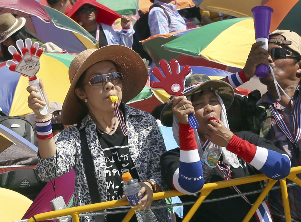 Anti-government protesters wave clapping tools and blow whistles during a rally at the Democracy Monument in Bangkok, Thailand, Sunday, Jan. 12, 2014. Thailand's capital is bracing for traffic chaos as anti-government demonstrators plan to occupy major road intersections in what they describe as an effort to shut down the city. (AP Photo/Apichart Weerawong)