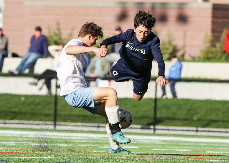 Rockland's Ty Comman is tripped up by East Bridgewater's Grady Dewhurst during a game on Monday, Oct. 16, 2023.