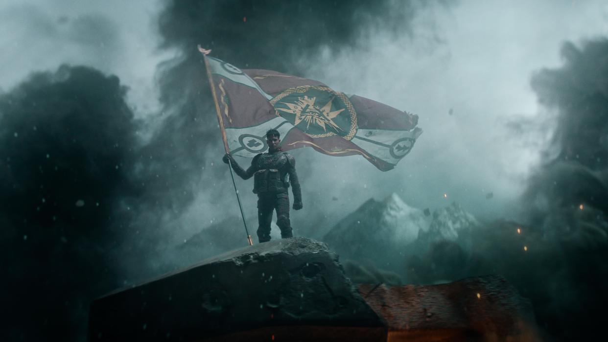  Kora holding a flag aloft in Rebel Moon - Part One: A Child of Fire. 