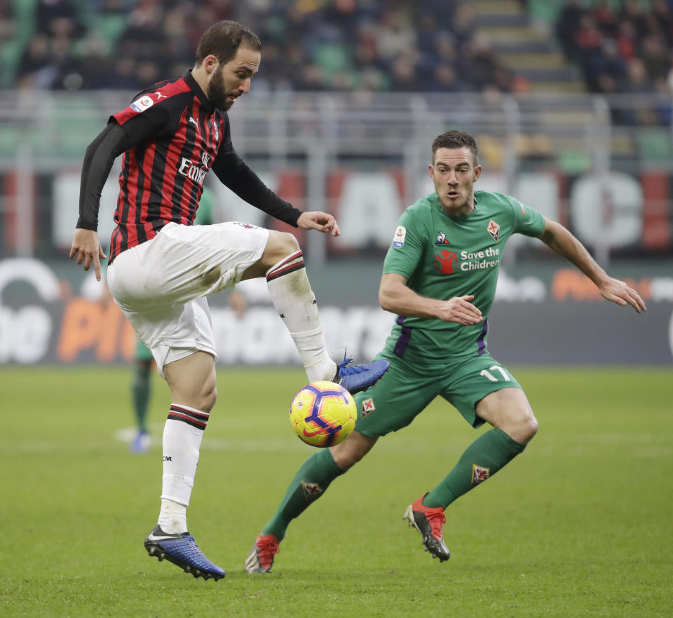 FILE - In this Saturday, Dec. 22, 2018 filer, AC Milan's Gonzalo Higuain, left, challenges for the ball with Fiorentina's Jordan Veretout during a Serie A soccer match between AC Milan and Fiorentina, at the San Siro stadium in Milan, Italy. Amid reports of an imminent move to Chelsea and a mysterious fever, Gonzalo Higuain again lost his cool against his former club in what could have been his last match for AC Milan. Higuain was on the bench for most of Wednesday's Italian Super Cup against Juventus, officially due to "fever", but came on for the final 20 minutes. The Argentina forward had little impact and could not prevent 10-man Milan losing to Juventus but still made the headlines for the wrong reasons. (AP Photo/Luca Bruno, File )