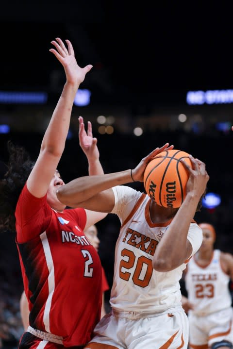 Texas forward Khadija Faye (20) looks to shoot as North Carolina State forward Mimi Collins (2) defends during the first half of an Elite Eight college basketball game in the women’s NCAA Tournament, Sunday, March 31, 2024, in Portland, Ore. (AP Photo/Howard Lao)