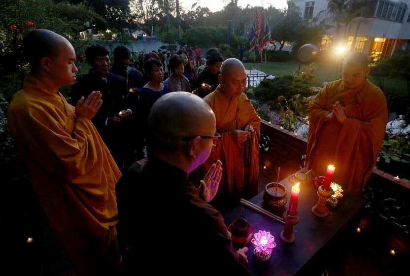 SANTA ANA, CALIF. - MAY, 2022. Buddhist monks lead prayers during a vigil for victims of the coronavirus, held on Tuesday night, May 17, 2022, at Viet Heritage House and Garden in Santa Ana.d. About 30 members of the Vietnamese - American community joined the vigil, which marked more than 1 million Americans dead from COVID-19. (Luis Sinco / Los Angeles Times)