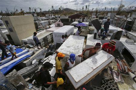 People carry a coffin with the remains of their relative, who was killed during Typhoon Haiyan, to a damaged cemetery during the victim's funeral in Palo November 16, 2013. Survivors began rebuilding homes destroyed by Haiyan, one of the world's most powerful typhoons, and emergency supplies flowed into ravaged Philippine islands, as the United Nations more than doubled its estimate of people made homeless to nearly two million. REUTERS/John Javellana