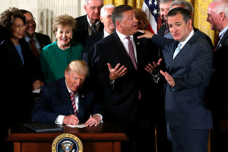 U.S. House Committee on Transportation and Infrastructure Chairman Representative Bill Shuster (R-PA) (2nd R) takes a gentle ribbing from Senator Ted Cruz (R-TX) (R) and others after Shuster asked U.S. President Donald Trump (seated) to sign autographs after Trump signed principles of proposed reforms to the U.S. air traffic control system during an event at the White House in Washington, DC, U.S. June 5, 2017. REUTERS/Jonathan Ernst