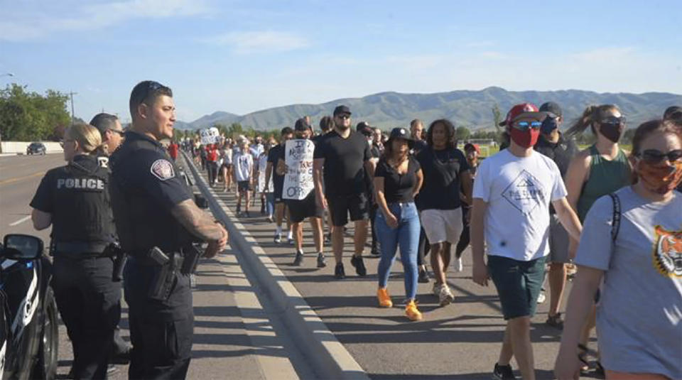 In this June 3, 2020, photo provided by Idaho State Athletics, people walk during a unity march, in Pocatello, Idaho. A strong connection between law enforcement and Idaho State student-athletes set the stage for the peaceful unity march. (Jarius Fields/Idaho State Athletics via AP)