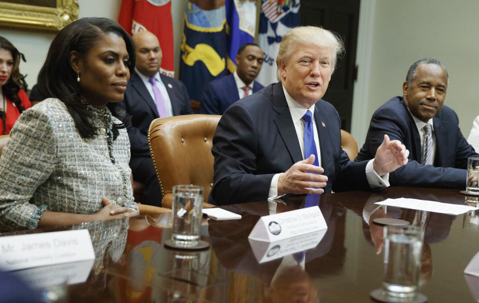 FILE - In this Feb. 1, 2017, file photo, President Donald Trump, center, is flanked by White House staffer Omarosa Manigault Newman, left, and then-Housing and Urban Development Secretary-designate Ben Carson as he speaks during a meeting on African American History Month in the Roosevelt Room of the White House in Washington. Manigault Newman, who was fired in December, released a new book "Unhinged," about her time in the White House. (AP Photo/Evan Vucci, File)