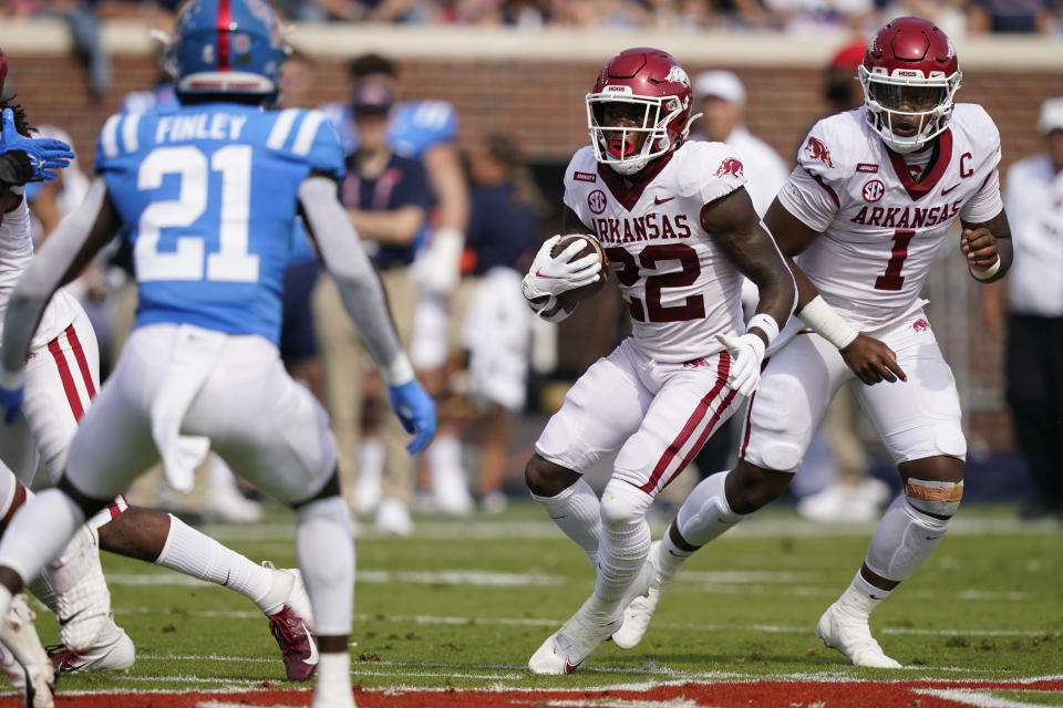 Arkansas running back Trelon Smith (22) takes the ball from quarterback <a class="link " href="https://sports.yahoo.com/ncaaf/players/301976" data-i13n="sec:content-canvas;subsec:anchor_text;elm:context_link" data-ylk="slk:KJ Jefferson;sec:content-canvas;subsec:anchor_text;elm:context_link;itc:0">KJ Jefferson</a> (1) as <a class="link " href="https://sports.yahoo.com/ncaaf/teams/mississippi/" data-i13n="sec:content-canvas;subsec:anchor_text;elm:context_link" data-ylk="slk:Mississippi;sec:content-canvas;subsec:anchor_text;elm:context_link;itc:0">Mississippi</a> defensive back AJ Finley (21) moves in to defend during the first half of an NCAA college football game, Saturday, Oct. 9, 2021, in Oxford, Miss. (AP Photo/Rogelio V. Solis)