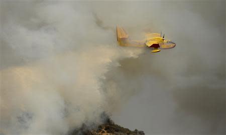 A "super scooper" air tanker makes waters drops as firefighters battle a fast-moving California wildfire, so-called the "Colby Fire", in the hills of Glendora January 16, 2014. REUTERS/Gene Blevins
