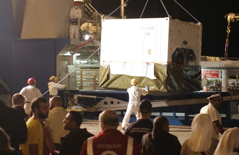 A container with the bodies of migrants is unloaded from the Swedish coast guard ship "Poseidon" in the port of Palermo on August 27, 2015