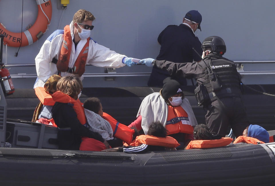 A Border Force vessel brings a group of people thought to be migrants into the port city of Dover, England, from small boats, Saturday Aug. 8, 2020. The British government says it will strengthen border measures as calm summer weather has prompted a record number of people to attempt the risky sea crossing in small vessels, from northern France to England. (AP Photo/Kirsty Wigglesworth)