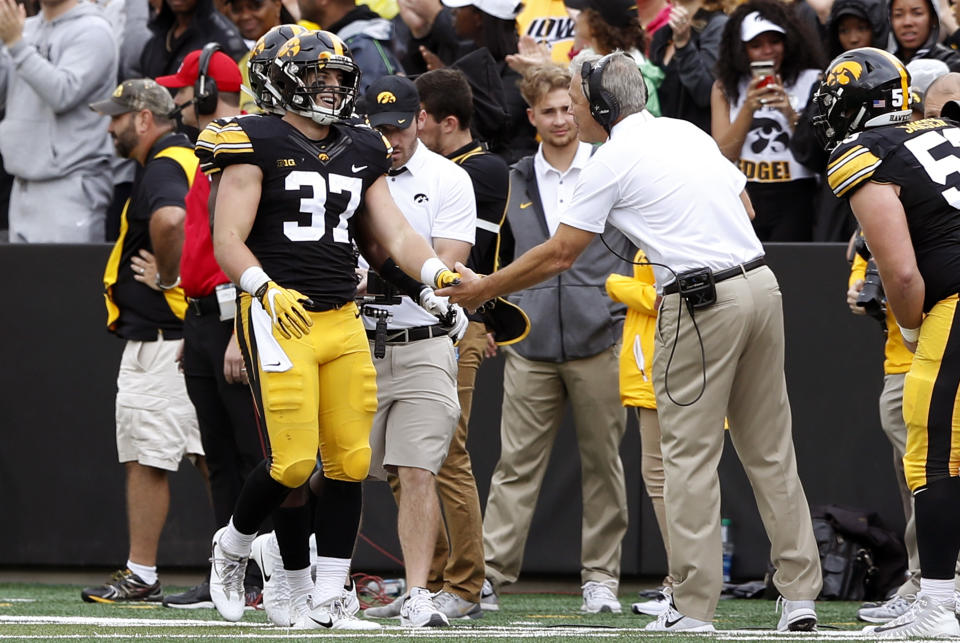 Iowa defensive back Brandon Snyder (37) celebrates with head coach Kirk Ferentz, right, after returning an interception 89-yards for a touchdown during the second half of an NCAA college football game against Illinois, Saturday, Oct. 7, 2017, in Iowa City, Iowa. Iowa won 45-16. (AP Photo/Charlie Neibergall)