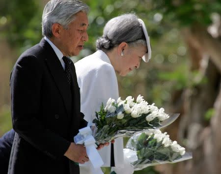 Japan's Emperor Akihito (L) and Empress Michiko lay flowers for the Japanese soldiers who died in the bloody World War Two Battle of Saipan at the Monument of the War Dead in the Mid-Pacific in Saipan June 28, 2005. REUTERS/Toshiyuki Aizawa/Files