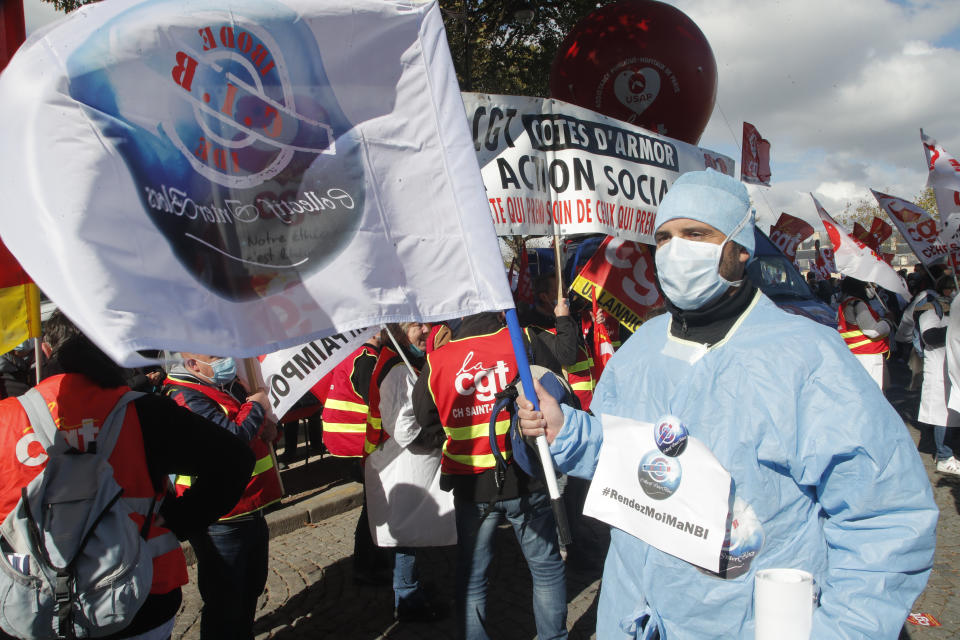 Medical workers demonstrate to demand better salaries and working conditions, Thursday, Oct. 15, 2020 in Paris. French President Emmanuel Macron has announced that millions of French citizens in several regions around the country, including in Paris, will have to respect a 9pm curfew from this Saturday until Dec. 1. It's a new measure aimed at curbing the resurgent coronavirus amid second wave. The measures will require citizens in certain regions where the coronavirus is circulating to be at home after 9pm. (AP Photo/Michel Euler)