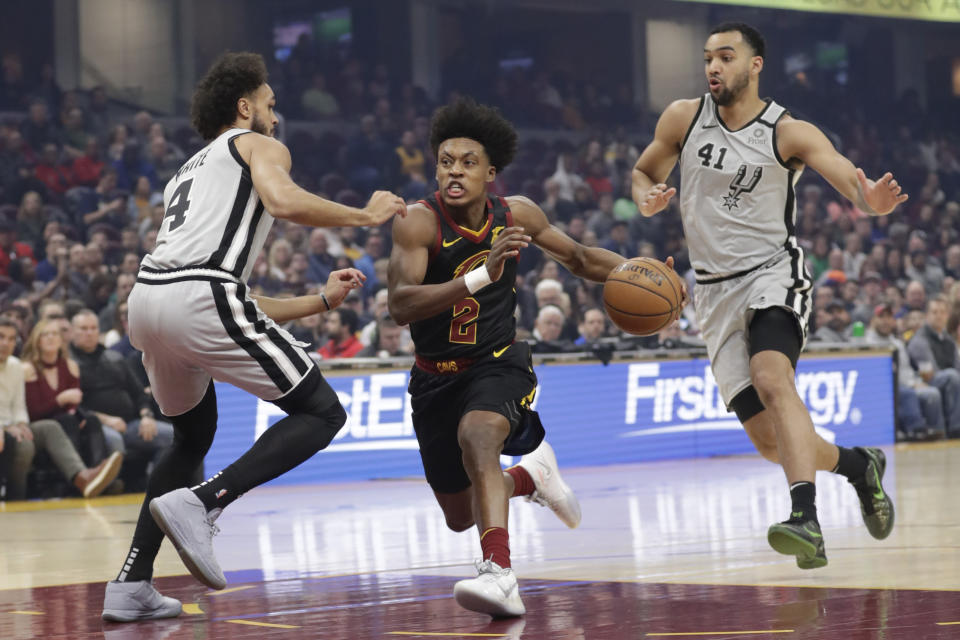 Cleveland Cavaliers' Collin Sexton (2) drivetrains vas past San Antonio Spurs' Derrick White (4) in the first half of an NBA basketball game, Sunday, March 8, 2020, in Cleveland. Trey Lyles (41) follows behind. (AP Photo/Tony Dejak)