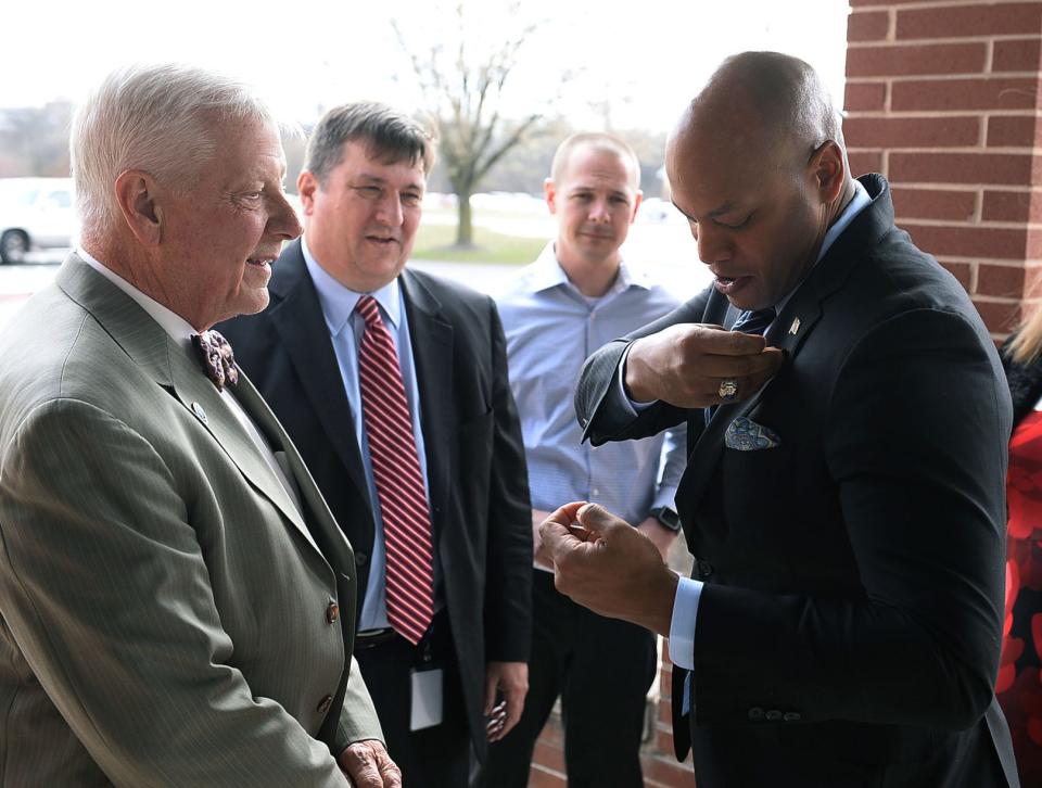 Maryland Gov. Wes Moore, right, attaches a lapel pin presented to him by Washington County Commissioners President John Barr, left, during the governor's visit Wednesday to Eastern Elementary School.