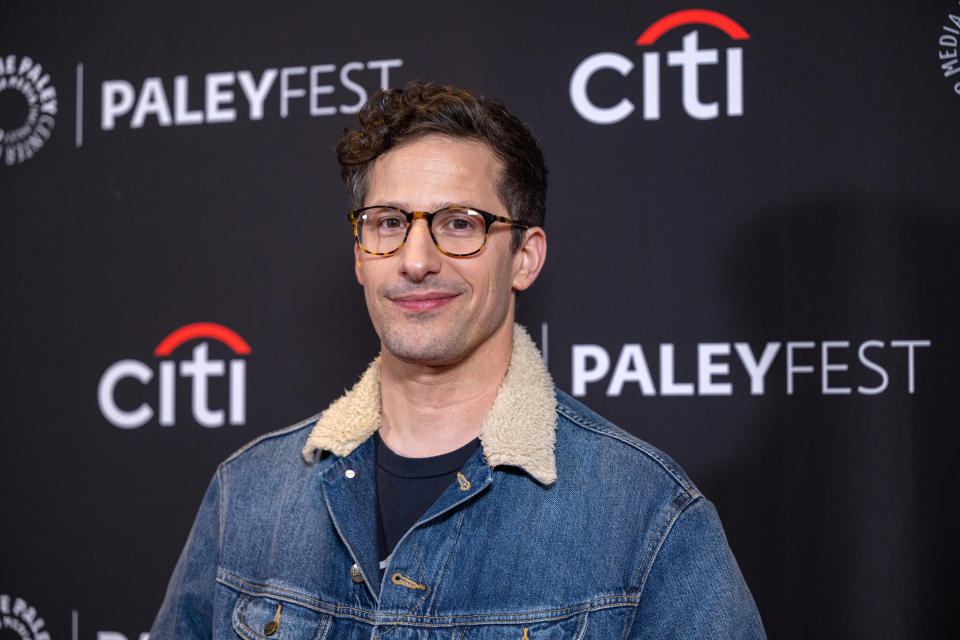 Andy Samberg at PaleyFest, wearing glasses and a jeans jacket with a shearling-lined collar