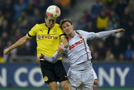 FC Augsburg's defender Sebastian Langkamp (R) and Dortmund's striker Robert Lewandowski jump for the ball during their German Bundesliga football match in Augsburg, southern Germany. Dortmund won 3-1