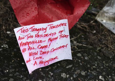 A note on a bouquet of flowers gets wet in the rain at a makeshift memorial outside Marysville-Pilchuck High School the day after a school shooting in Marysville, Washington October 25, 2014. REUTERS/Jason Redmond