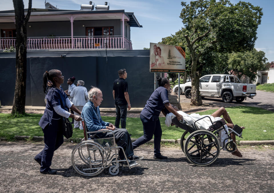 People are taken away from an old aged home close to where a truck carrying liquified petroleum gas exploded in Boksburg, east of Johannesburg, Saturday, Dec. 24, 2022. A truck carrying liquified petroleum gas has exploded in the South African town of Boksburg, east of Johannesburg, killing at least 8 people and injuring 50 others on Saturday. (AP Photo/Shiraaz Mohamed)