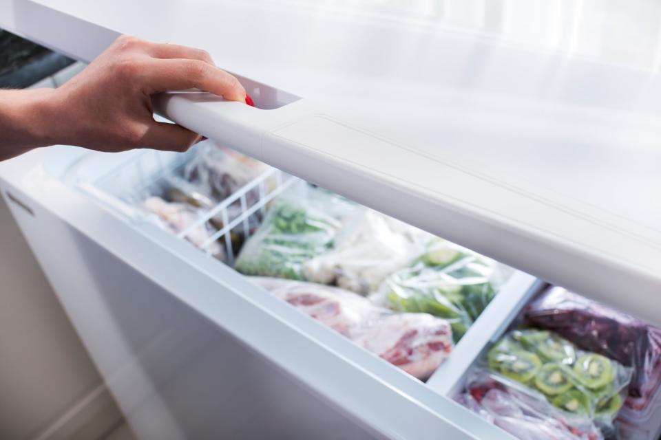 Woman hand opening a refrigerator door