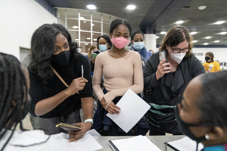 Denice Asbell, left, brings her daughter Rhegan, 13, center, down to the central counting board to observe democratic election challengers watching ballots being counted in the early morning hours of Wednesday, Nov. 4, 2020 in Detroit. (AP Photo/David Goldman)