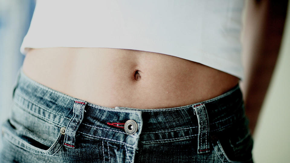 close up of a young slim white woman's belly button